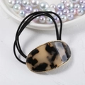 Close-up of tortoiseshell acetate oval hair tie with gold trim and black elastic band - Light Coffee