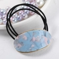 Detail of elegant acetate hair ring with blue pink marble texture and gold twisted frame - Blue