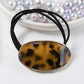 Detail of tortoise shell acetate hair tie with golden metal rim and black elastic band - Vintage Tortoiseshell Decor / Amber