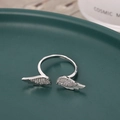 Elegant silver open ring with pavé crystal feather wings on a green ceramic tray - Silver (D7306)