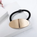 Minimalist elastic hair tie with large polished golden oval metal piece on white steps - Oval (c6103) / Oval Gold