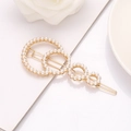 Elegant gold hair clip with hollow circles and white pearls on white background - Circular B8531