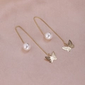 Detailed view of long gold chain earrings with butterfly pendant and pearl on pink silk - Polished Butterfly Gold A1212
