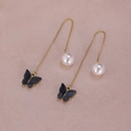 Close-up of gold chain earrings featuring black butterfly charms and white pearls - Black Butterfly Style (A2220)