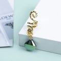 Dettaglio del ciondolo a spirale dorato con un cristallo verde sfaccettato per capelli - Oro Antico Verde Minerale