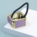 Detailed close-up of a square gold metal hair cuff with purple glitter and elastic band - Purple