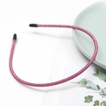 Detail of pink glitter headband with non-slip teeth on a green ceramic plate - Pink (E2505)
