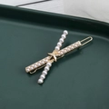 Elegante fermaglio dorato con perle e stella su vassoio verde scuro e pizzo - Stile Perla Artificiale