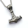 Detailed macro view of silver Viking Mjolnir pendant with intricate Celtic knot patterns - Thor's Hammer Style