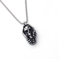 Makro-Detail eines gotischen Sarganhängers mit 3D-Totenkopf-Relief an einer Vintage-Kette - Skelett-Stil