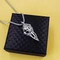 Silver vintage Viking raven skull necklace with engraved details on black box and yellow backdrop - Eagle Beak + Steel Chain