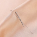 Detail view of silver ear crawler with sparkling round zircons on champagne satin fabric - Criss-Cross Silver
