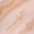 Detail of a gold cross ear crawler with sparkling zircons on elegant champagne satin fabric - Seven Stones Gold