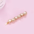Macro view of gold flower hair clip featuring shiny rhinestones and elegant pearls - S-Shaped Rhinestone (C1403)