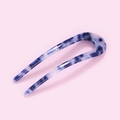 Dettaglio della forcina a U in acetato marmorizzato blu e bianco su sfondo rosa - Blu Reale (E7120)