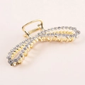 Dettaglio di un grande fermaglio per capelli in metallo dorato con strass scintillanti - Stile Strass (E8229)