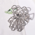 Close-up of a silver bear-shaped hair claw clip with a hollow metal design and sturdy spring - Silver Panda with White Eye
