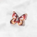 Vue détaillée d'une pince à cheveux papillon orange réaliste ornée de strass brillants - Rouge (M3120)
