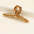 Close-up of a large amber resin hair claw clip with a matte finish on silk fabric - Dark Coffee