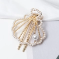 Detalle de pinza para el cabello de concha dorada con perlas sobre seda blanca - Estilo Concha Perla (C5330)