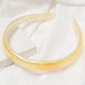 Detail van een transparante haarband gevuld met gouden lovertjes op wit satijn - Gele Stijl (E1320) / Geel