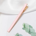Detailed view of a pastel pink rectangular metal hair clip on silk fabric background - Pink