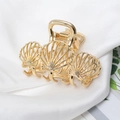 Primer plano de pinza de pelo de metal dorado con forma de concha sobre seda blanca - Estilo Concha Pequeña (E1426)