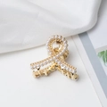 Detail of elegant gold claw clip with inlaid pearls on a soft white silk background - Cross Style (c5229)