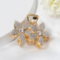 Gros plan sur la pince à cheveux dorée ornée de deux fleurs et de strass étincelants - Style Floral (E7420)