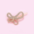 Détail d'une pince à cheveux papillon dorée avec strass brillants sur fond rose - Style Nœud Papillon (C7104)
