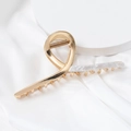 Macro detail of large golden metal shark hair claw with white marble resin inlay texture - Beige (B4105)