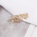 Detail of a gold-tone hair clip featuring pearls, rhinestones, and heart-shaped letter charms - XZ Gold