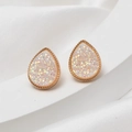 Macro detail of rose gold teardrop earrings with white crystal druzy on silk fabric - Light Pink