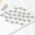 Set aus 25 silbernen Metall-Haarringen für Dreadlocks auf weißem Seidenhintergrund - Silber