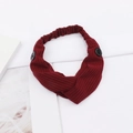 Detail of burgundy ribbed knit headband with side buttons and stylish twist design - Burgundy