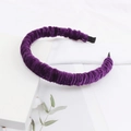 Detailopname van dieppaarse fluwelen hoofdband met geplooide textuur en zachte stof - Paars