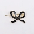 Detailed view of a black enamel bow hair clip with gold alloy plating for women - Snap Clip / Black