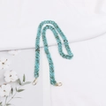 Detail of blue acrylic leopard print chain with golden lobster clasps on white fabric - Cyan Amber Texture (K3409)