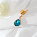 Macro detail of a gold spiral hair ring with a blue crystal teardrop pendant - Green (E8422)