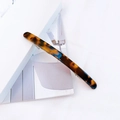 Close-up of a tortoiseshell acetate hair clip with a sturdy silver metal spring clip - Amber