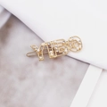 Elegant gold YIBO hair clip with white pearls and sparkling rhinestones on fabric background - YIBO Gold