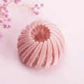 Vue macro d'une pince à cheveux rose poudré en velours avec un design extensible en nid d'oiseau - Rose Floqué