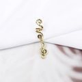 Detailed macro view of a vintage gold alloy hair ring with a treble clef music note charm - Treble Clef Note Style (E7522-23#)