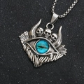 Primer plano del collar gótico con tres calaveras y colgante de ojo de cristal azul - Ojo del Diablo Azul con Cadena de Acero