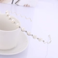 Classic silver wavy headband with white pearls and sparkling rhinestones on a coffee cup - Silver (C7334)