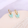 Vue détaillée des boucles d'oreilles papillon dorées avec émail bleu et cristaux - Bleu lac