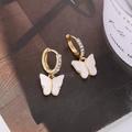 Détail de boucles d'oreilles papillon en acrylique blanc avec strass brillants sur l'anneau - Blanc (A7235A)