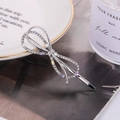 Barrette à cheveux nœud argenté avec strass brillants sur un fond de style minimaliste - Argent (C4501)