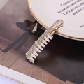 Elegant gold rhinestone hair clip with large rectangular crystals on white ceramic - Gold E1324