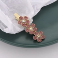 Detail of pink crystal flower hair clip with gold metal base on a green display tray - Flower Style